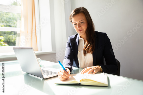 Businesswoman Writing Note In Diary