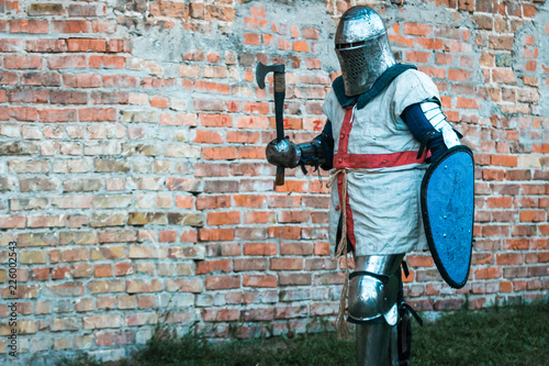 Medieval knight in armor with an ax and shield.