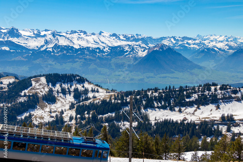 view of alpine train running in beautiful alps mountain switzerland europe on calm sunny day
