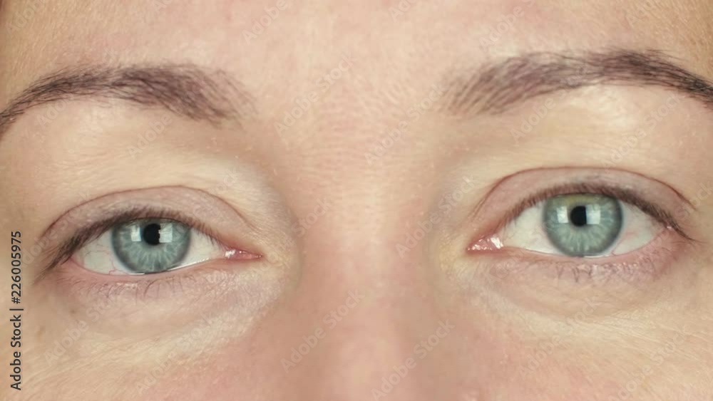 Woman open eyes and blinking front camera. Close up face adult woman winking eye