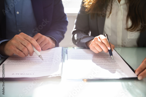 Two Businesspeople Working On Contract Paper
