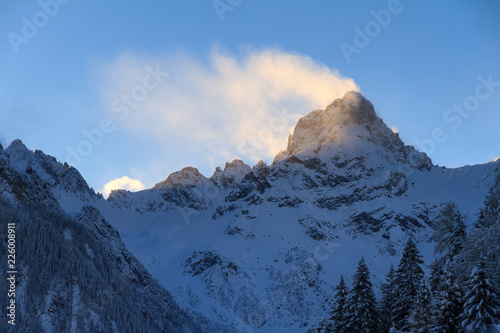 Beautiful morning sunrise view of backlit mountain tops with snow and clouds in the Brandnertal in the Alps in Vorarlberg  Austria  in winter