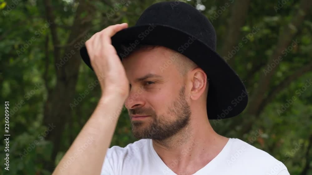 Bearded man in a hat smilling and squints his eyes Bearded man in a hat smilling and squints his eyes