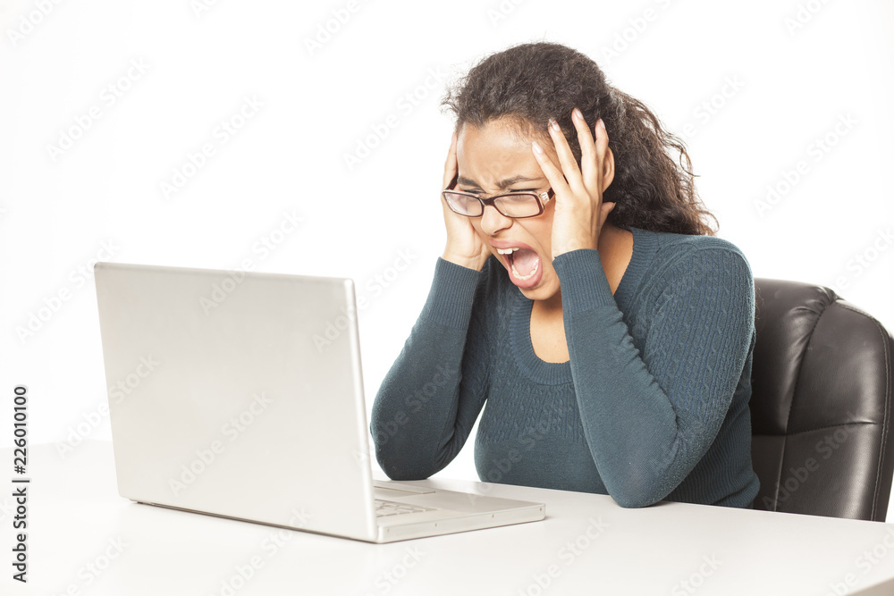 Frustrated young african woman at her laptop on white background Frustrated young african woman at her laptop on white background