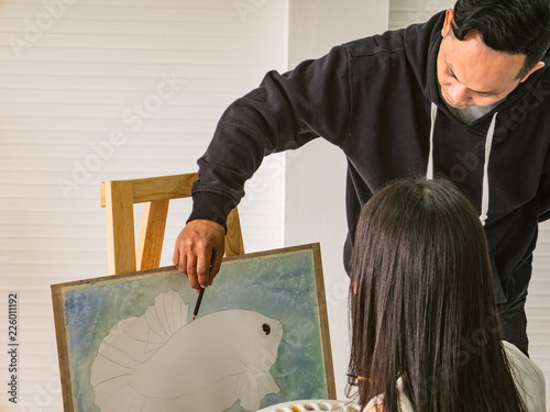 Handsome Young Asian man or water color artist Teaching how to paint and artist student Learning the class in Classroom,fish concept