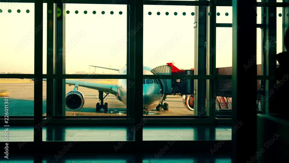 Airport time lapse involving airfield traffic and boarding airplane with attached jet bridge