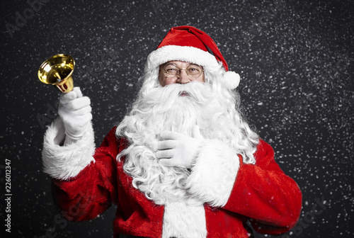 Cheerful santa claus holding handbell © gpointstudio