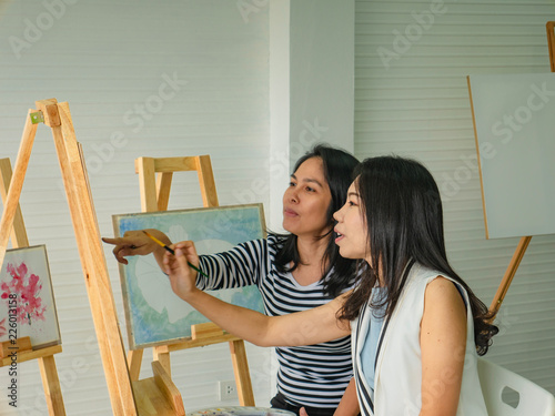 Two young asian woman artist dawning while useing ideas to think and create the best artwork together,fish concept