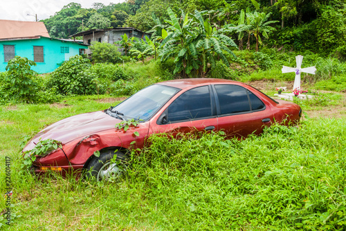 Wrecked car and a cross in Portobelo village, Panama