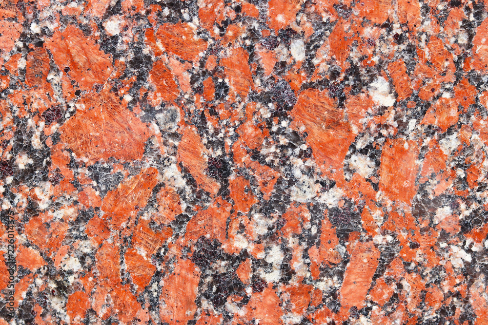 The background of polished granite in red black shades. A background for design and creative work. Decoration and exterior decoration of the building. Construction works. The background of polished granite in red black shades. A background for design and creative work. Decoration and exterior decoration of the building. Construction works.