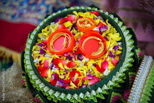 Bride price in thai wedding ceremony, gold bacelet on the green plate and colorful petal
