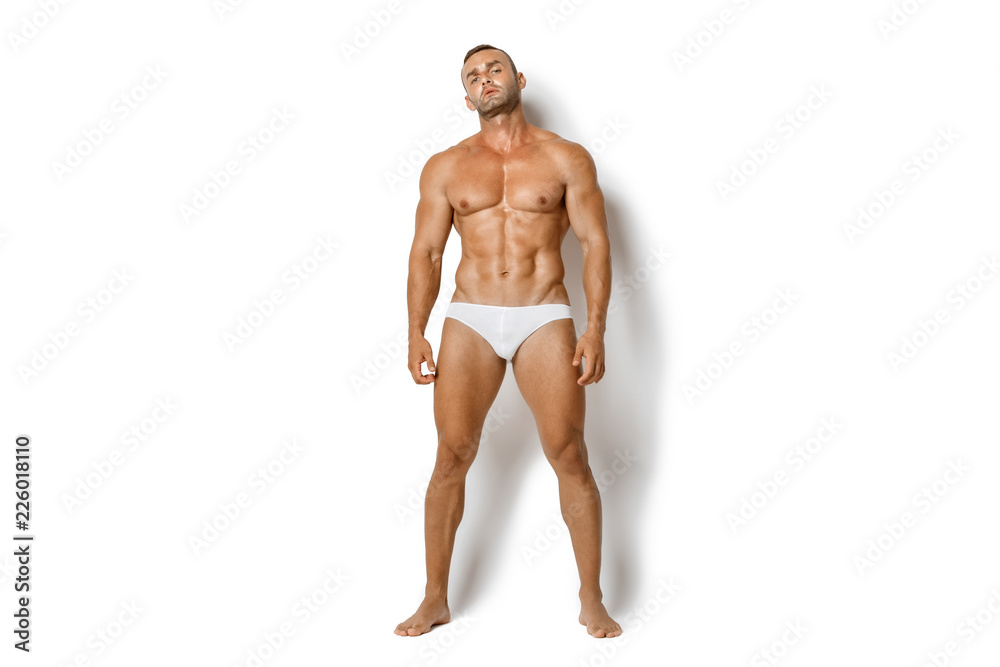 Strong stripped muscle male model in white underwear on white isolated font background