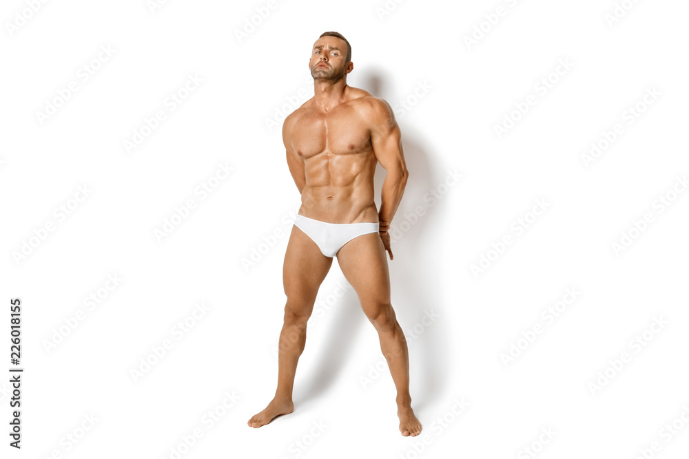 Strong stripped muscle male model in white underwear on white isolated font background Strong stripped muscle male model in white underwear on white isolated font background
