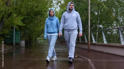 Front view of young couple walking in nature, park together. Man and woman walking and hold hands. photo