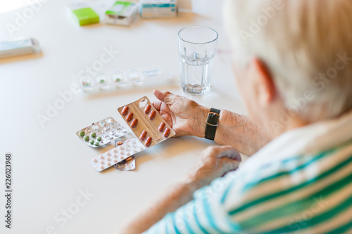 Senior woman holding medicine and pills in her hand