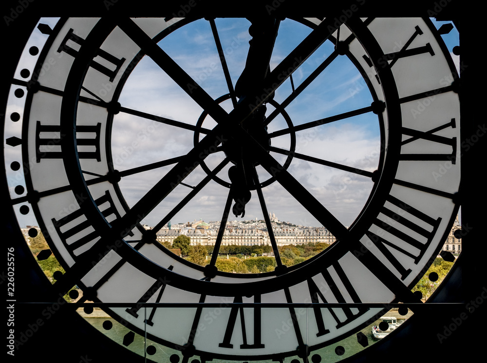 Fototapeta Paris cityscape through the giant clock at the Musee d'Orsay with view on the Seine river, Tuileries Garden, Palais royal, Opera Garnier, Sacre-Coeur and Montmartre hill - Paris, France