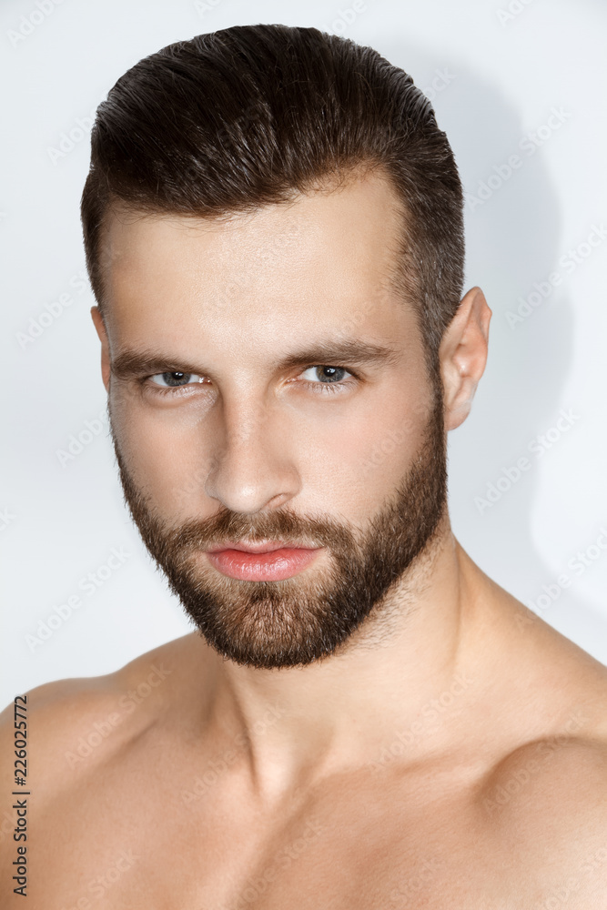 Handsome muscled strong face stripped male model in black underwear on white isolated font background Handsome muscled strong face stripped male model in black underwear on white isolated font background