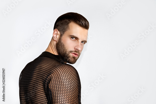 Handsome muscled strong face male model in fashion cloathes on white isolated font background photo