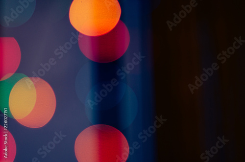 Defocused colorful garland lights bokeh on dark background © Anastasia
