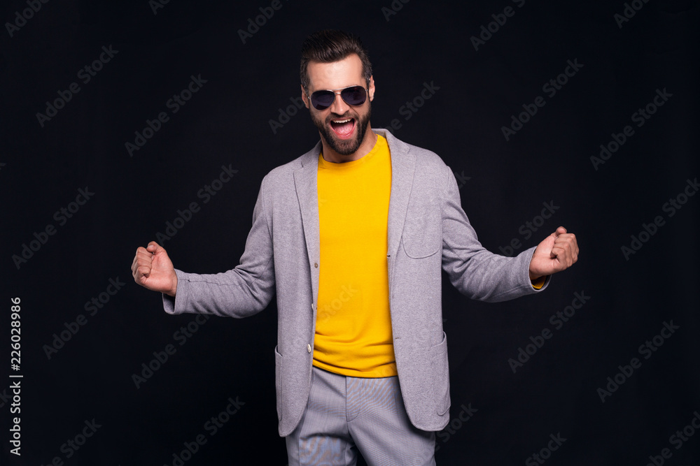Yeeeees! Handsome young man gesturing and looking at camera with smile while standing against black background