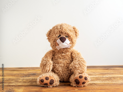 Kindesmissbrauch, Teddybär mit Heftpflaster auf dem Mund photo