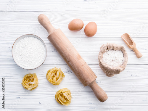 Ingredients for homemade pasta flour and eggs on wooden background.