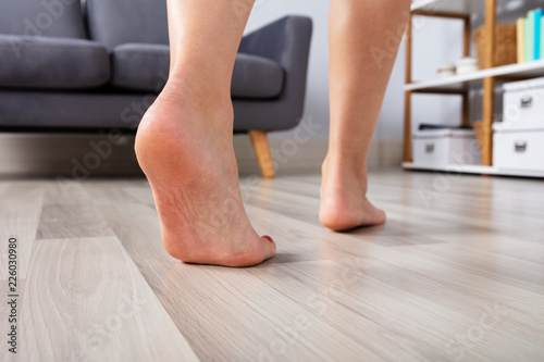 Woman's Foot Walking On Hardwood Floor