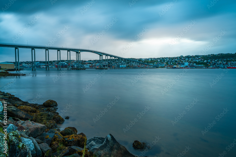 Naklejka premium View of Tromso Bridge across Tromsoysundet strait in Norway at dusk. It connects Tromso on island of Tromsoya with Tromsdalen on mainland