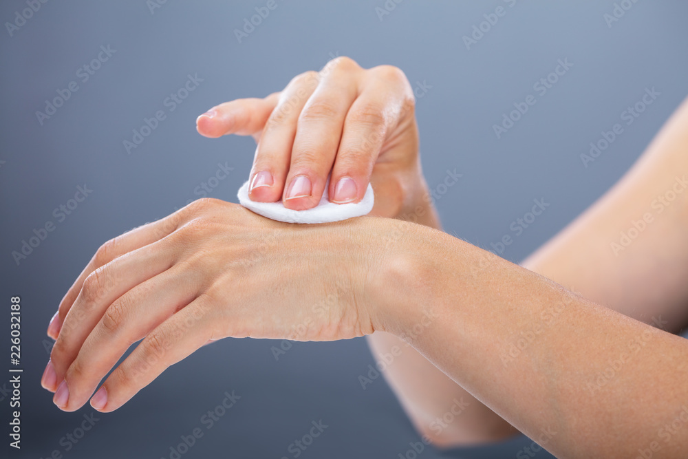 Woman Cleaning Her Hand With Cotton Pad