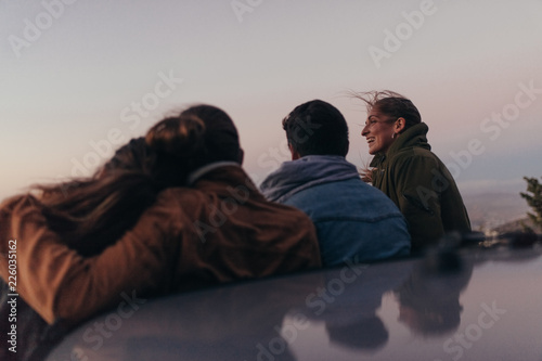Two couples standing on the hilltop spending time together