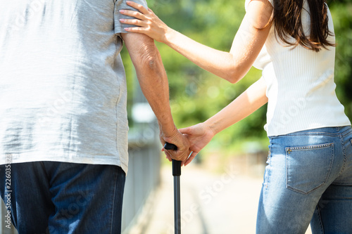 Foto Woman Assisting Her Father While Walking
