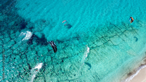Aerial drone photo of famous for watersports like kitesurfing sandy turquoise beach of Agios Ioannis with old abandoned wimdills and lovely clouds, Lefkada island, Ionian, Greece