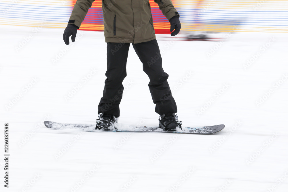 A guy is riding a snowboard from a mountain in winter A guy is riding a snowboard from a mountain in winter