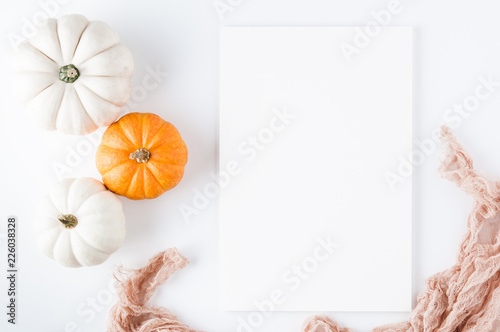pumpkins beside a blank sheet of paper for a thanksgiving saying