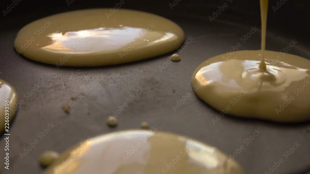 Cooking pancakes on special pan in the kitchen at home. Slow motion. Closeup. Cooking pancakes on special pan in the kitchen at home. Slow motion. Closeup.