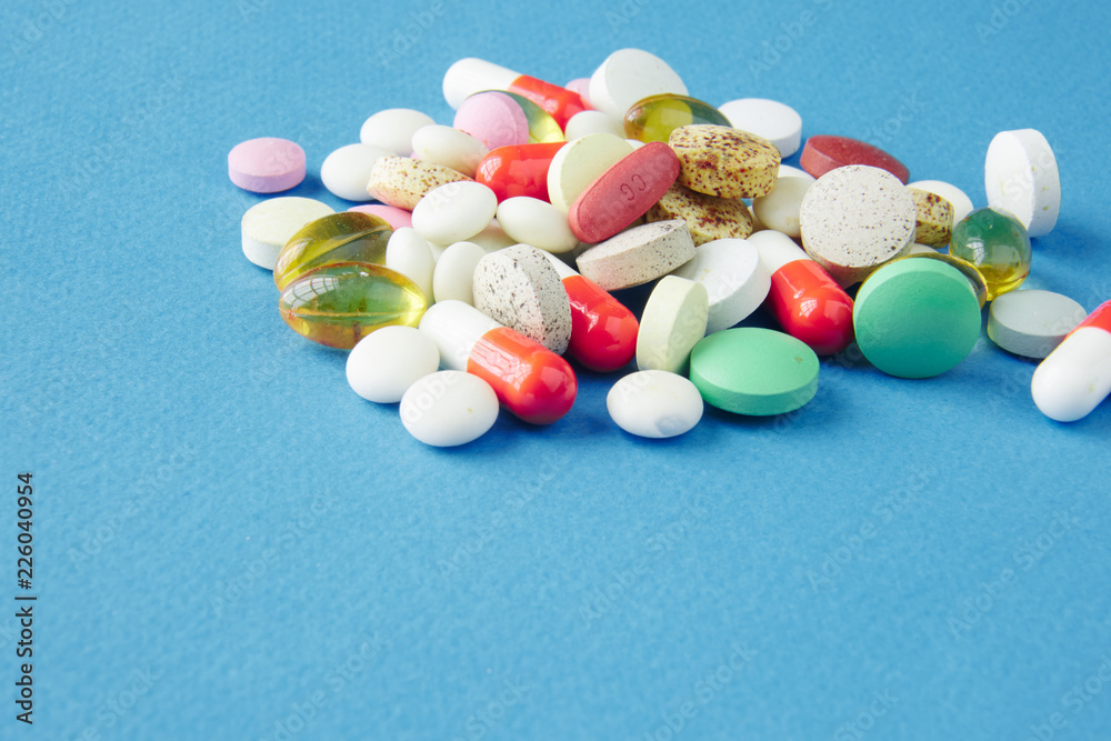 Pills are scattered over a blue background Pills are scattered over a blue background