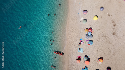 Aerial drone bird's eye view photo of popular beach of Milos with turquoise clear waters and sun beds, island of Lefkada, Ionian, Greece