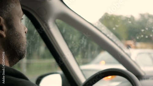 Wallpaper Mural Young man driving a car through the streets of new york on a rainy day. Inside shoot Torontodigital.ca