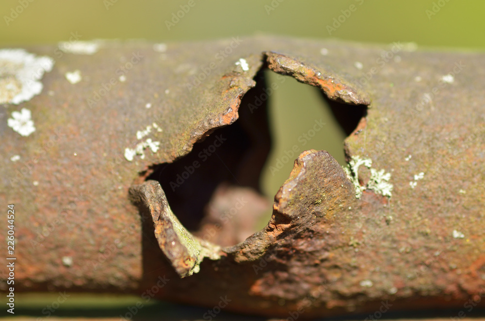 Rusty pipe with a hole.