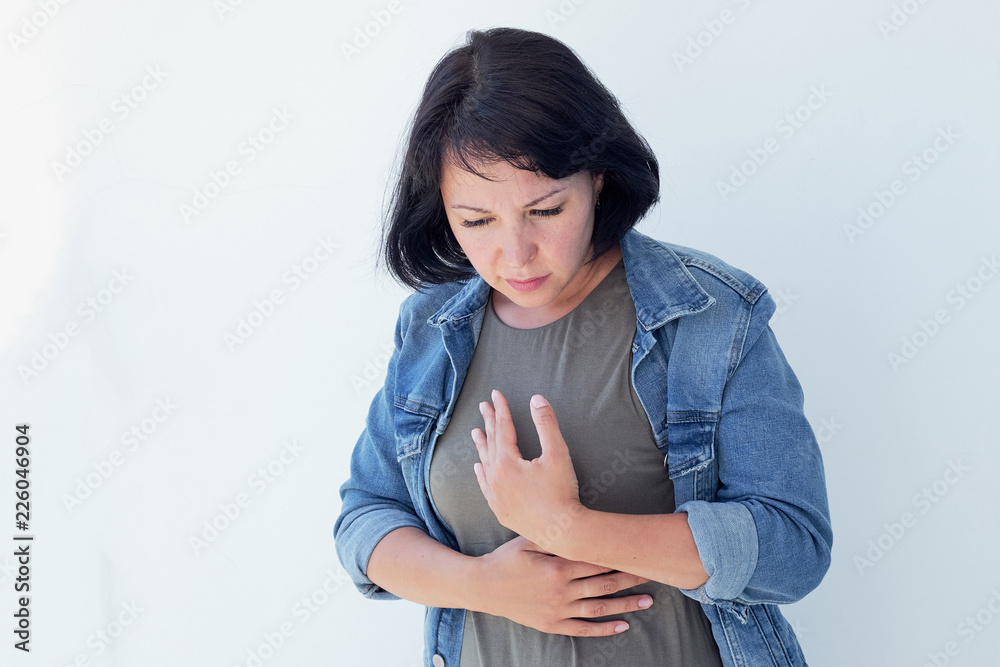 Aches and pains concept. Sick woman having bad ache and pain heart attack health problem. Female placing hands on her chest. Aches and pains concept. Sick woman having bad ache and pain heart attack health problem. Female placing hands on her chest.