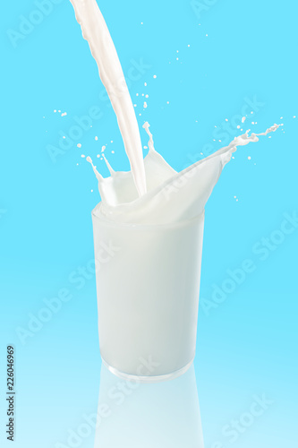Pouring a glass of milk creating splash on blue background
