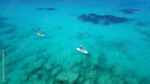 Aerial drone photo of couples practicing Stand Up Paddle or SUP in famous watersports beach of Agios Ioannis, Lefakada island, Ionian, Greece