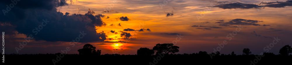  Sunlight with dramatic sky. Cumulus sunset clouds with sun setting down on dark background.orange and dark cloud sky.