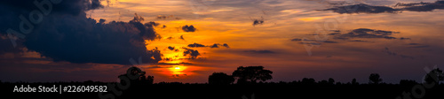  Sunlight with dramatic sky. Cumulus sunset clouds with sun setting down on dark background.orange and dark cloud sky.