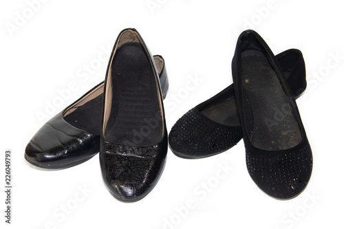 Black ballet flats on female legs on a white background. Women's summer footwear. Business black ballet shoes on a white background. Shoes without a heel. Comfortable casual shoes