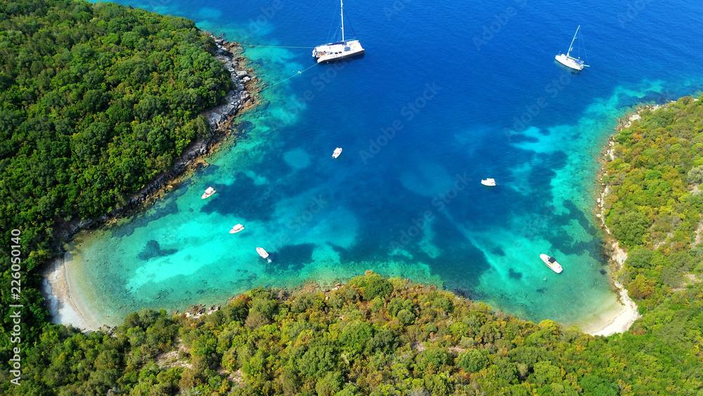 Aerial drone bird's eye view photo of iconic paradise sandy beach of blue lagoon with deep turquoise clear sea and pine trees  in complex island of Mourtos in Sivota area, Epirus, Greece