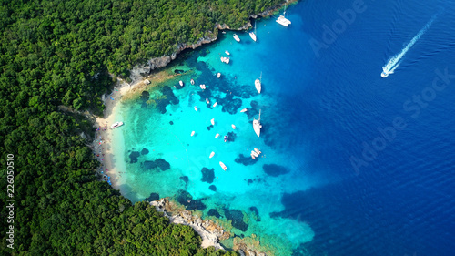 Aerial drone bird's eye view photo of iconic paradise sandy beach of blue lagoon with deep turquoise clear sea and pine trees  in complex island of Mourtos in Sivota area, Epirus, Greece photo