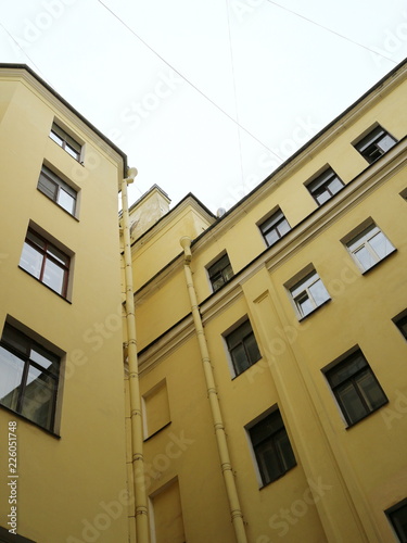 walls of a yellow high-rise building at a sharp angle © Andrey