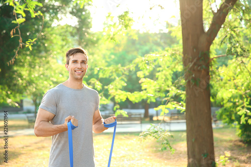 Smiling young man exercisin...