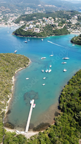 Aerial photo of tropical exotic paradise vegetated island with blue lagoon  white sandy beaches and turquoise sea with sail boats and yachts docked